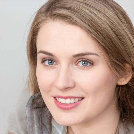 Joyful white young-adult female with long  brown hair and blue eyes