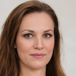 Joyful white young-adult female with long  brown hair and green eyes