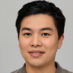 Joyful asian young-adult male with short  brown hair and brown eyes