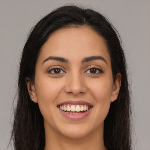Joyful latino young-adult female with long  brown hair and brown eyes