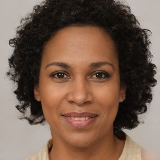 Joyful black adult female with medium  brown hair and brown eyes