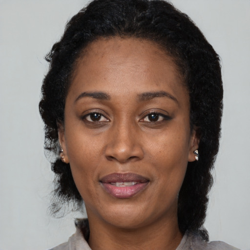 Joyful black adult female with medium  black hair and brown eyes