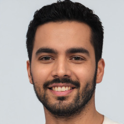 Joyful latino young-adult male with short  black hair and brown eyes