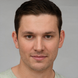 Joyful white young-adult male with short  brown hair and grey eyes