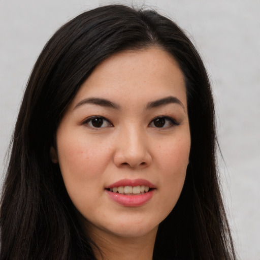 Joyful asian young-adult female with long  brown hair and brown eyes
