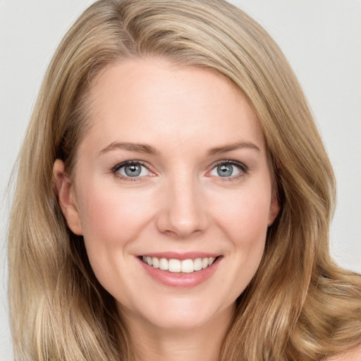 Joyful white young-adult female with long  brown hair and blue eyes