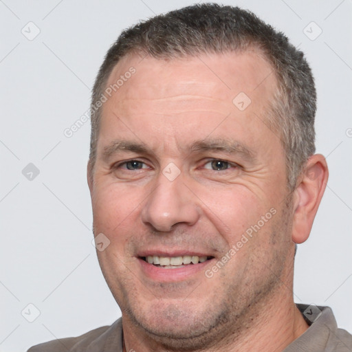 Joyful white adult male with short  brown hair and brown eyes