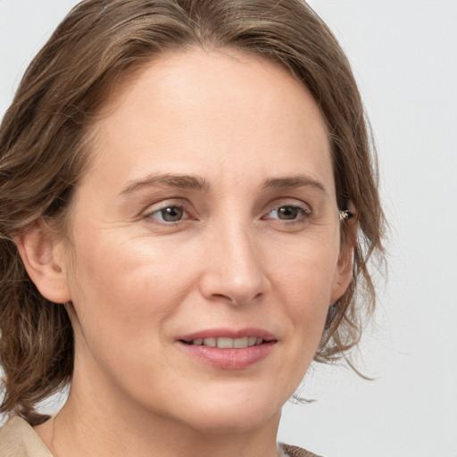 Joyful white adult female with medium  brown hair and grey eyes