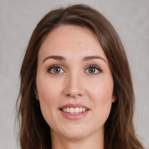 Joyful white young-adult female with long  brown hair and green eyes