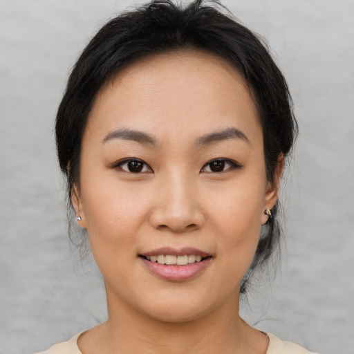 Joyful asian young-adult female with medium  brown hair and brown eyes