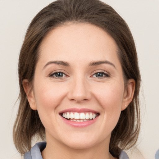 Joyful white young-adult female with medium  brown hair and grey eyes