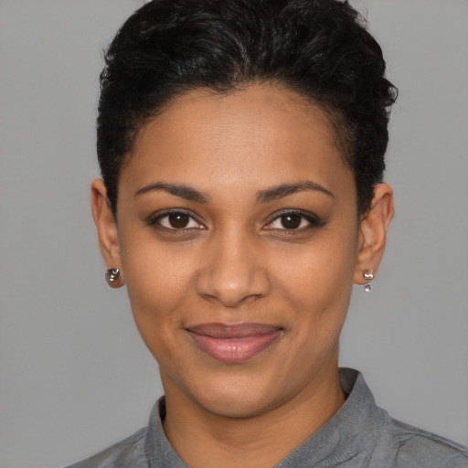 Joyful black young-adult female with short  black hair and brown eyes
