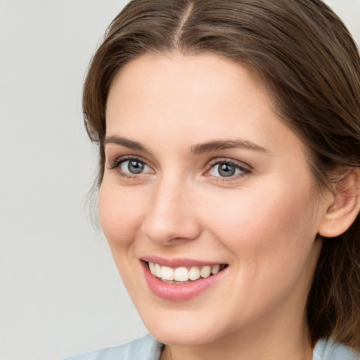 Joyful white young-adult female with medium  brown hair and blue eyes