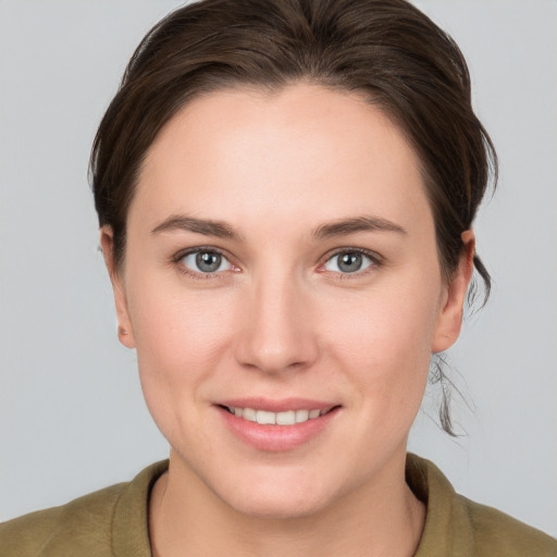 Joyful white young-adult female with medium  brown hair and grey eyes