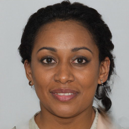 Joyful black adult female with short  brown hair and brown eyes