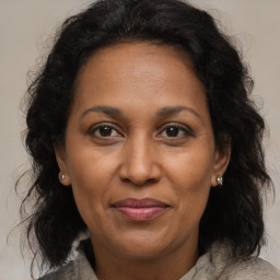 Joyful black adult female with medium  brown hair and brown eyes