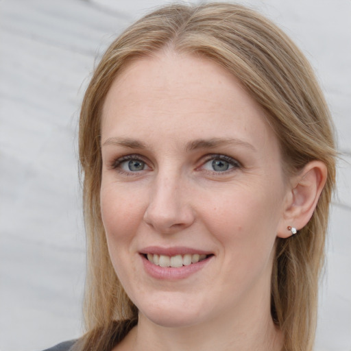 Joyful white young-adult female with long  brown hair and blue eyes