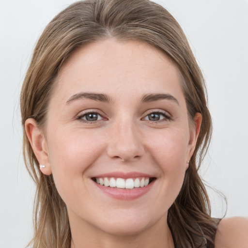 Joyful white young-adult female with long  brown hair and blue eyes