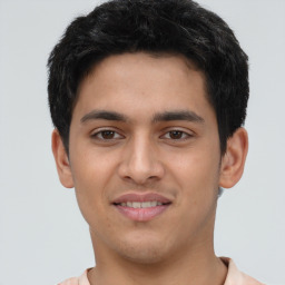 Joyful latino young-adult male with short  brown hair and brown eyes