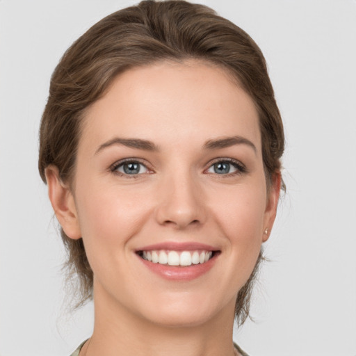 Joyful white young-adult female with medium  brown hair and grey eyes