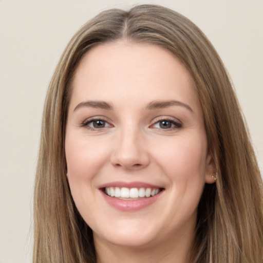 Joyful white young-adult female with long  brown hair and grey eyes