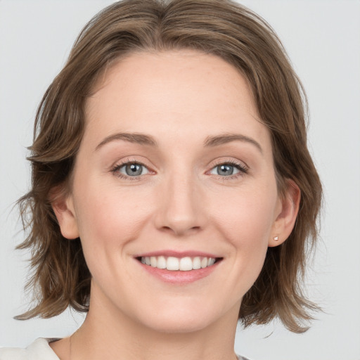 Joyful white young-adult female with medium  brown hair and blue eyes