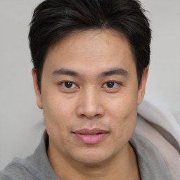 Joyful asian young-adult male with short  brown hair and brown eyes