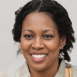 Joyful black adult female with medium  brown hair and brown eyes