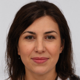 Joyful white adult female with long  brown hair and brown eyes