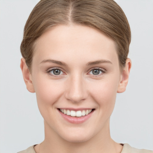 Joyful white young-adult female with short  brown hair and grey eyes