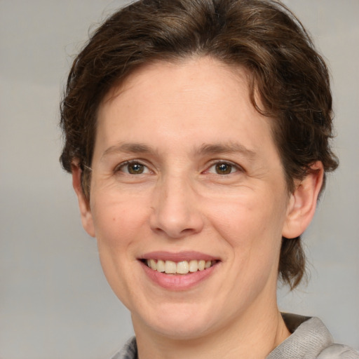 Joyful white adult female with medium  brown hair and green eyes