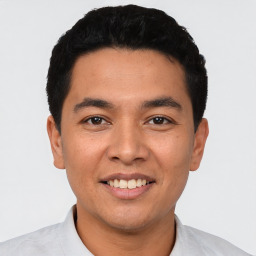 Joyful latino young-adult male with short  black hair and brown eyes