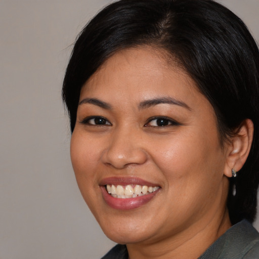 Joyful latino young-adult female with medium  black hair and brown eyes