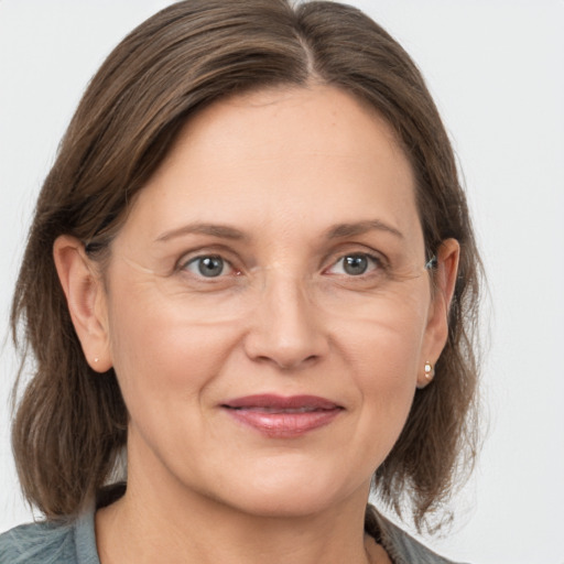 Joyful white adult female with medium  brown hair and grey eyes