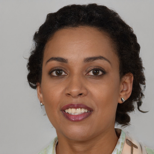 Joyful black young-adult female with medium  brown hair and brown eyes