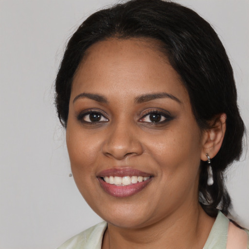 Joyful black young-adult female with medium  brown hair and brown eyes