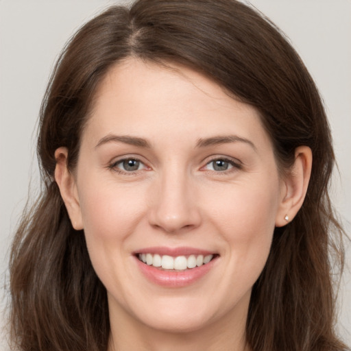 Joyful white young-adult female with long  brown hair and grey eyes