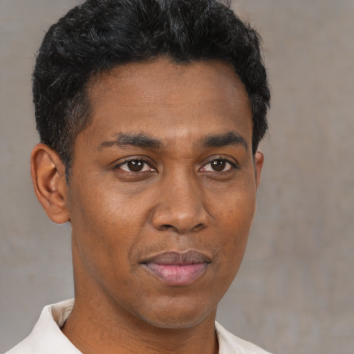 Joyful latino young-adult male with short  brown hair and brown eyes
