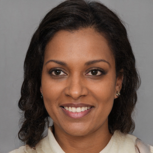 Joyful black young-adult female with medium  brown hair and brown eyes