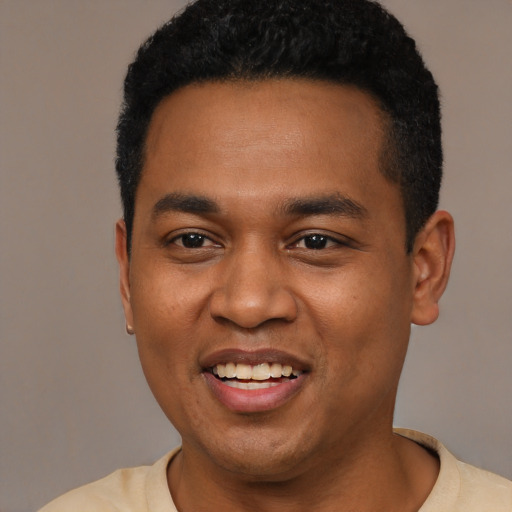 Joyful black young-adult male with short  black hair and brown eyes