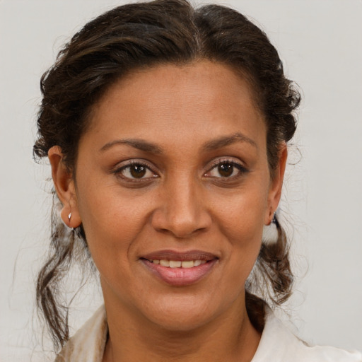 Joyful latino adult female with medium  brown hair and brown eyes