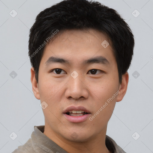 Joyful asian young-adult male with short  black hair and brown eyes