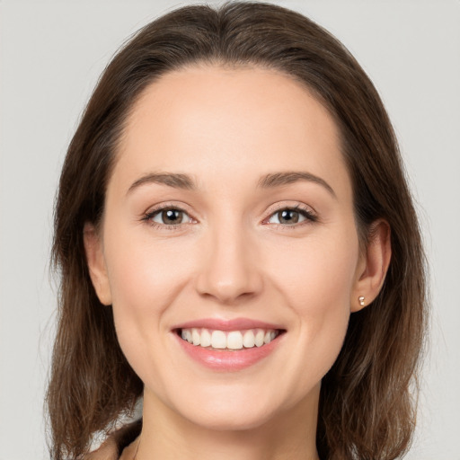 Joyful white young-adult female with medium  brown hair and grey eyes