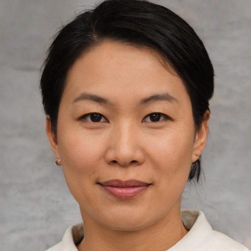 Joyful asian young-adult female with medium  brown hair and brown eyes