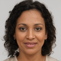 Joyful black adult female with medium  brown hair and brown eyes