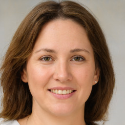 Joyful white young-adult female with medium  brown hair and green eyes