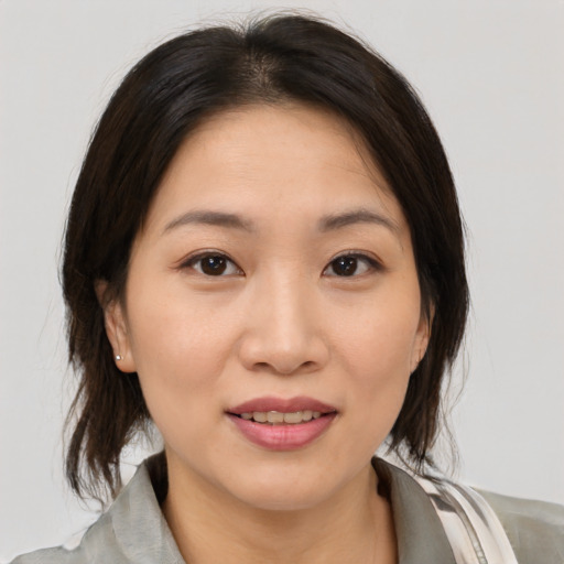 Joyful asian young-adult female with medium  brown hair and brown eyes