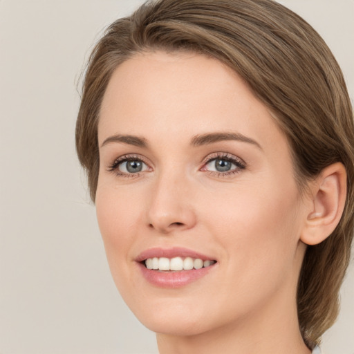 Joyful white young-adult female with medium  brown hair and green eyes