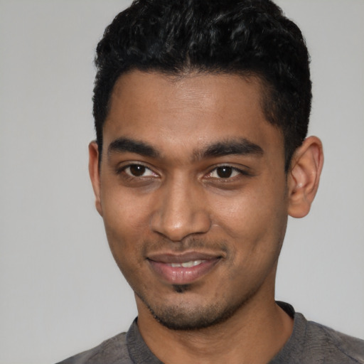 Joyful black young-adult male with short  black hair and brown eyes