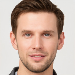 Joyful white young-adult male with short  brown hair and grey eyes